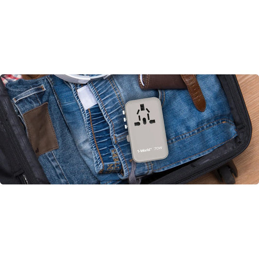 Gray Momax 70W travel adapter packed in suitcase with denim jeans for trip readiness
