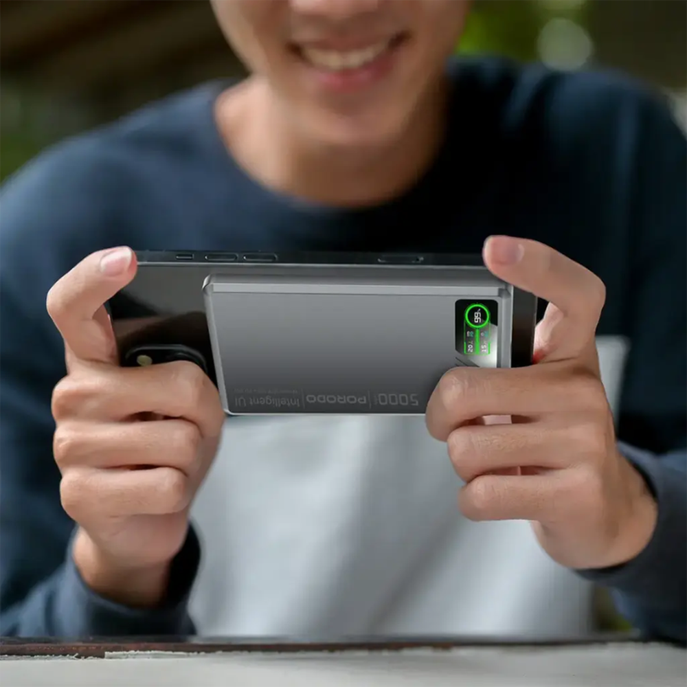 Person using gray Porodo 20W magnetic power bank attached to smartphone for gaming