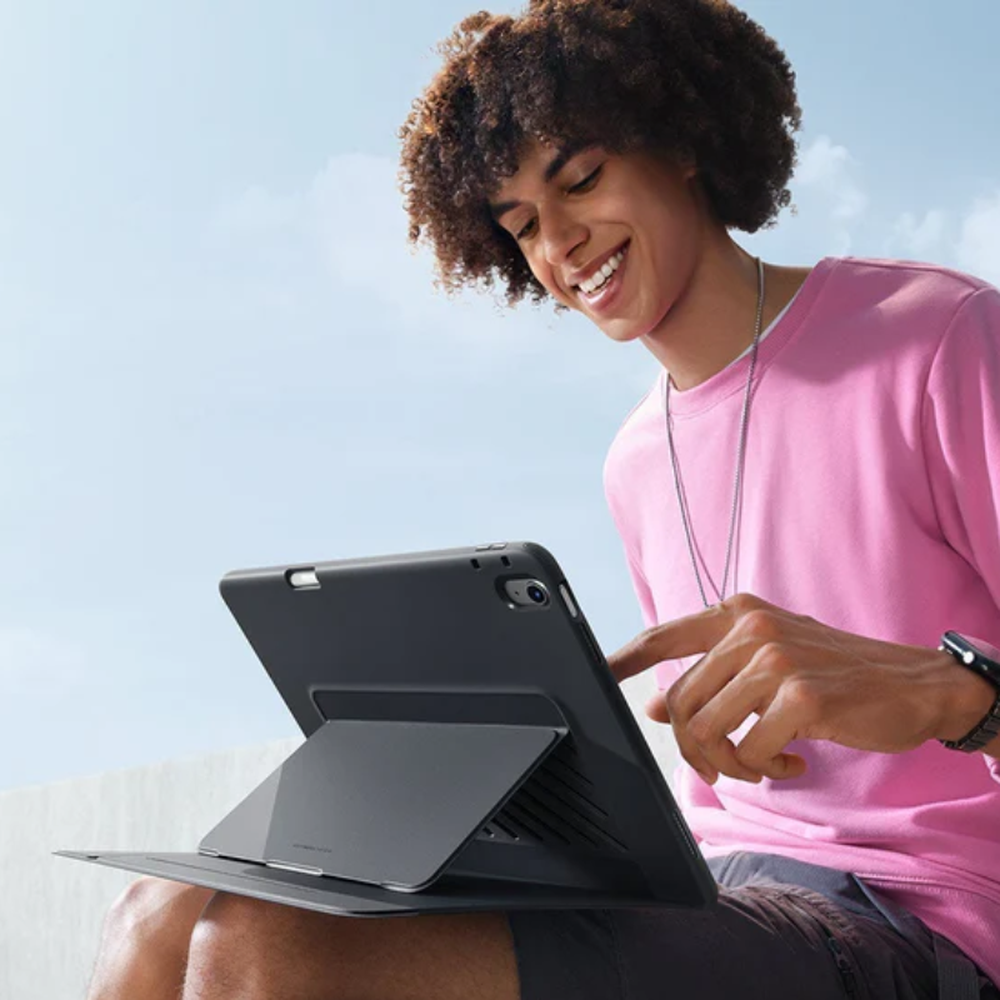 Person outdoors using black ESR iPad case as a stable magnetic stand