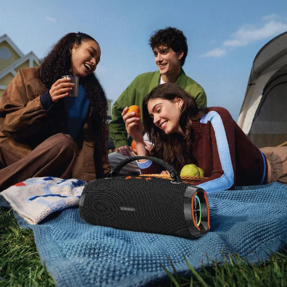 Black soundtec 100W portable speaker with RGB lights and orange buttons on outdoor blanket