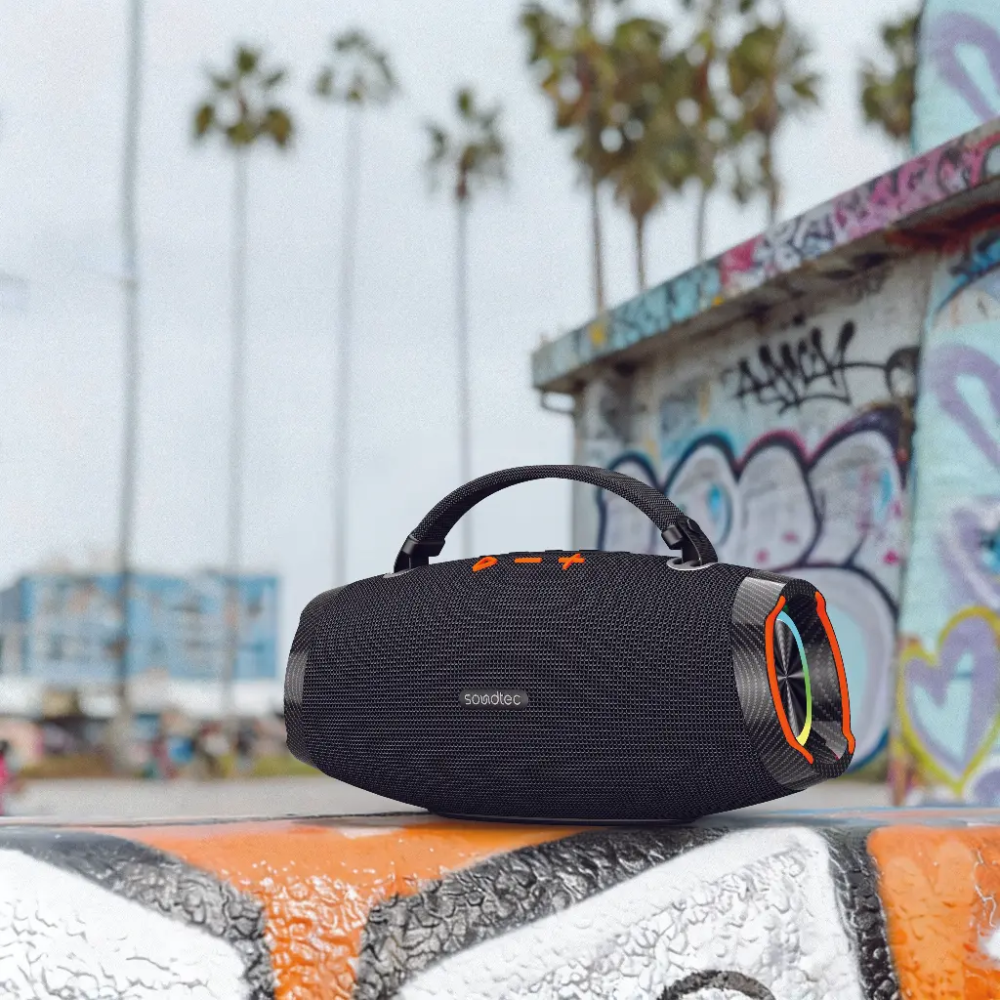 Water-resistant black soundtec Bluetooth speaker with rainbow LED ring on wet concrete ledge