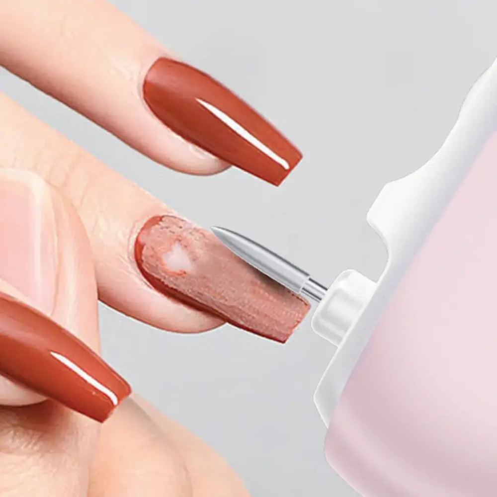 Electric nail drill removing brown polish from long nails with handheld device