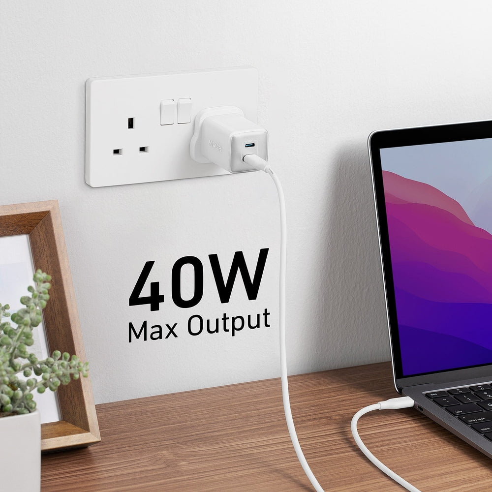 White Anker 40W dual port charger powering laptop on wooden desk setup