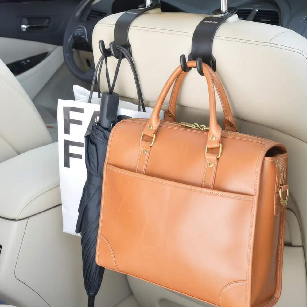 Dual black headrest hooks organizing umbrella and shopping bag