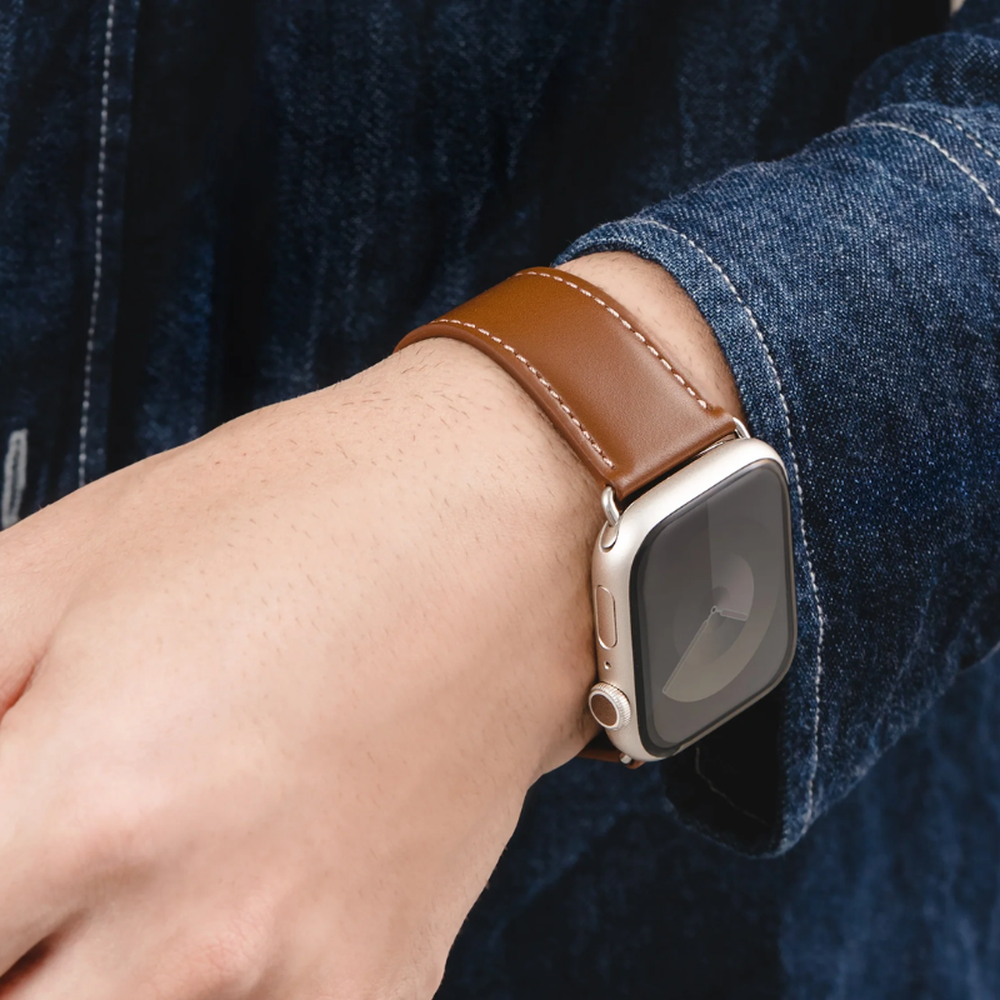 Brown leather Apple Watch band worn with denim shirt for casual style