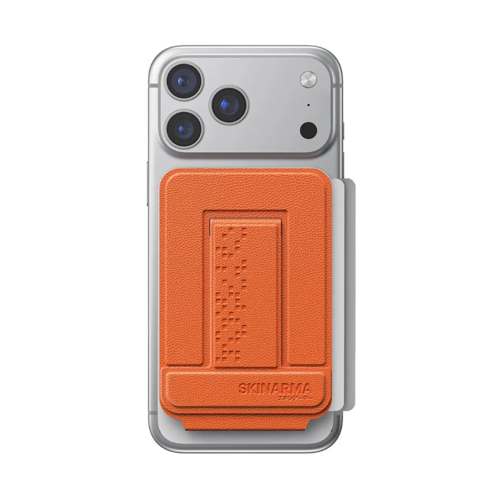 Orange Skinarma magnetic card holder with white card slot on vertical silver phone