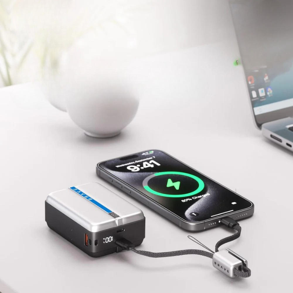 Brave 65W PowerBank charging smartphone with LED display on desk