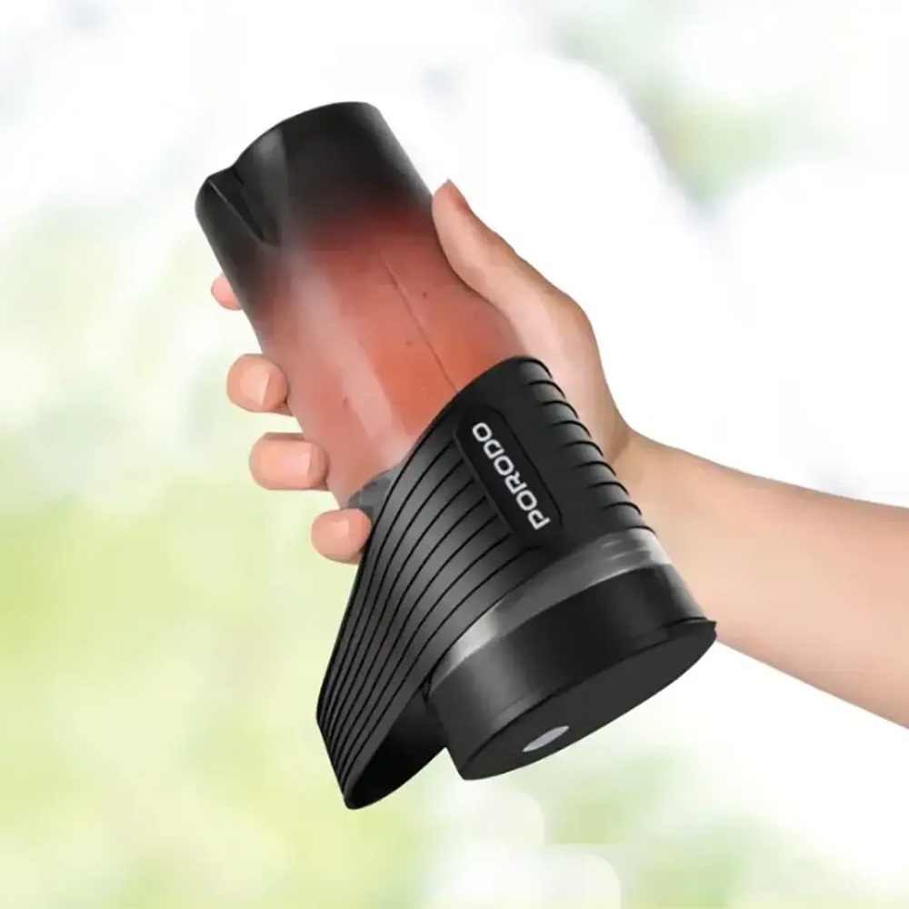 Hand holding red smoothie in black Porodo portable blender with ribbed grip