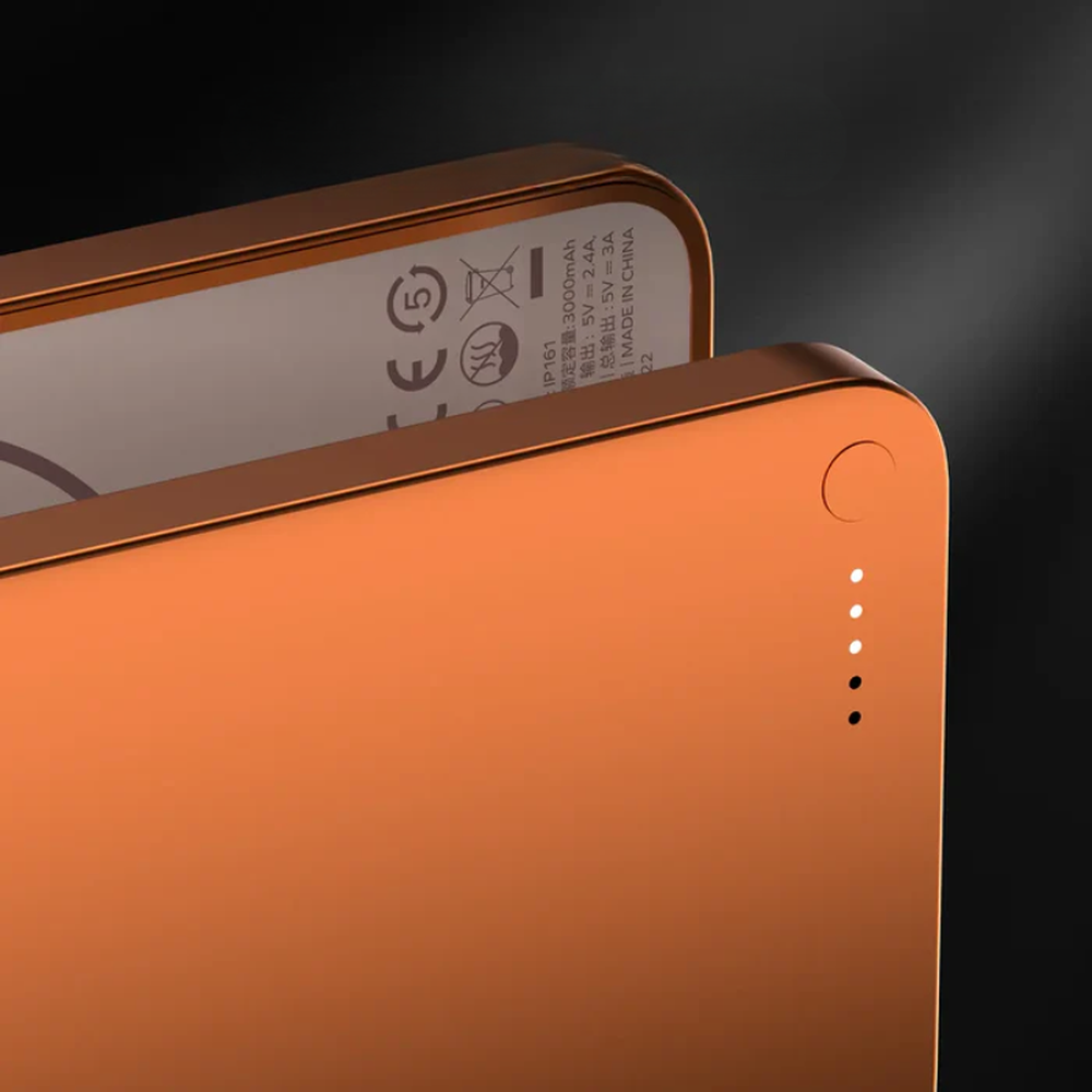Close-up of orange power bank LED indicators and button detail
