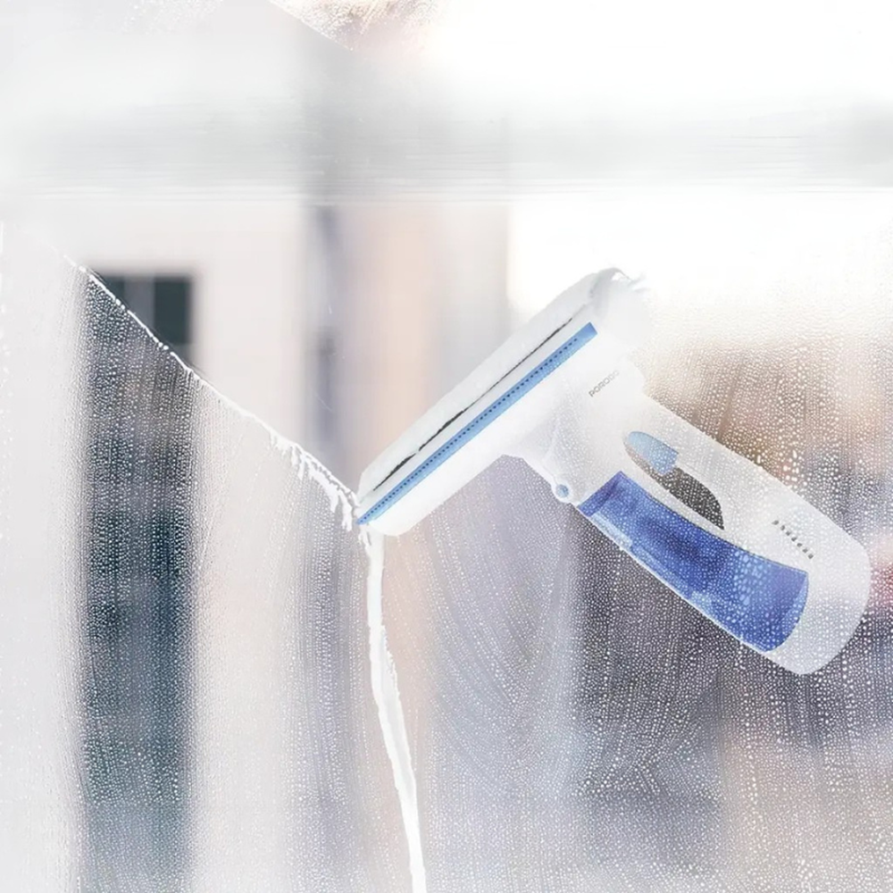 Porodo cordless window cleaner spraying and wiping soapy glass with microfiber squeegee