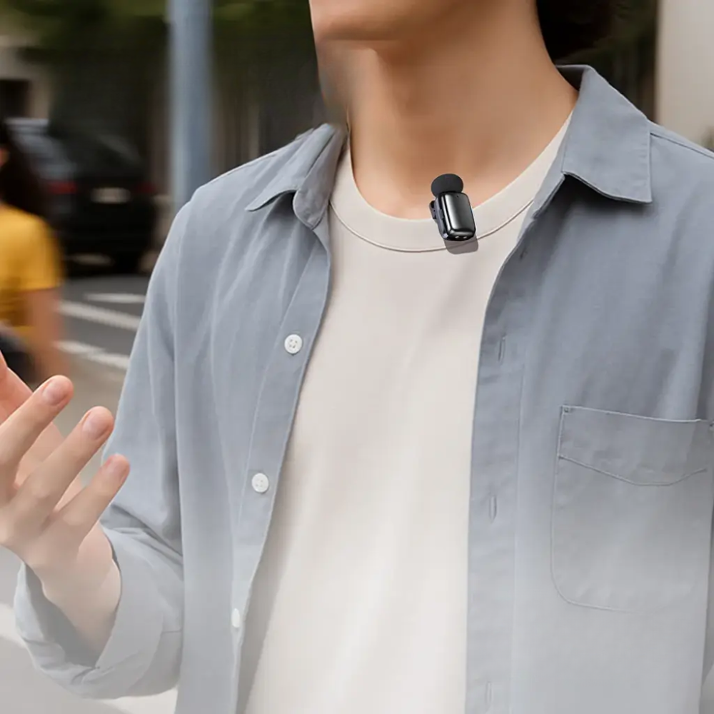Black Porodo wireless transmitter clipped to shirt collar with foam windscreen