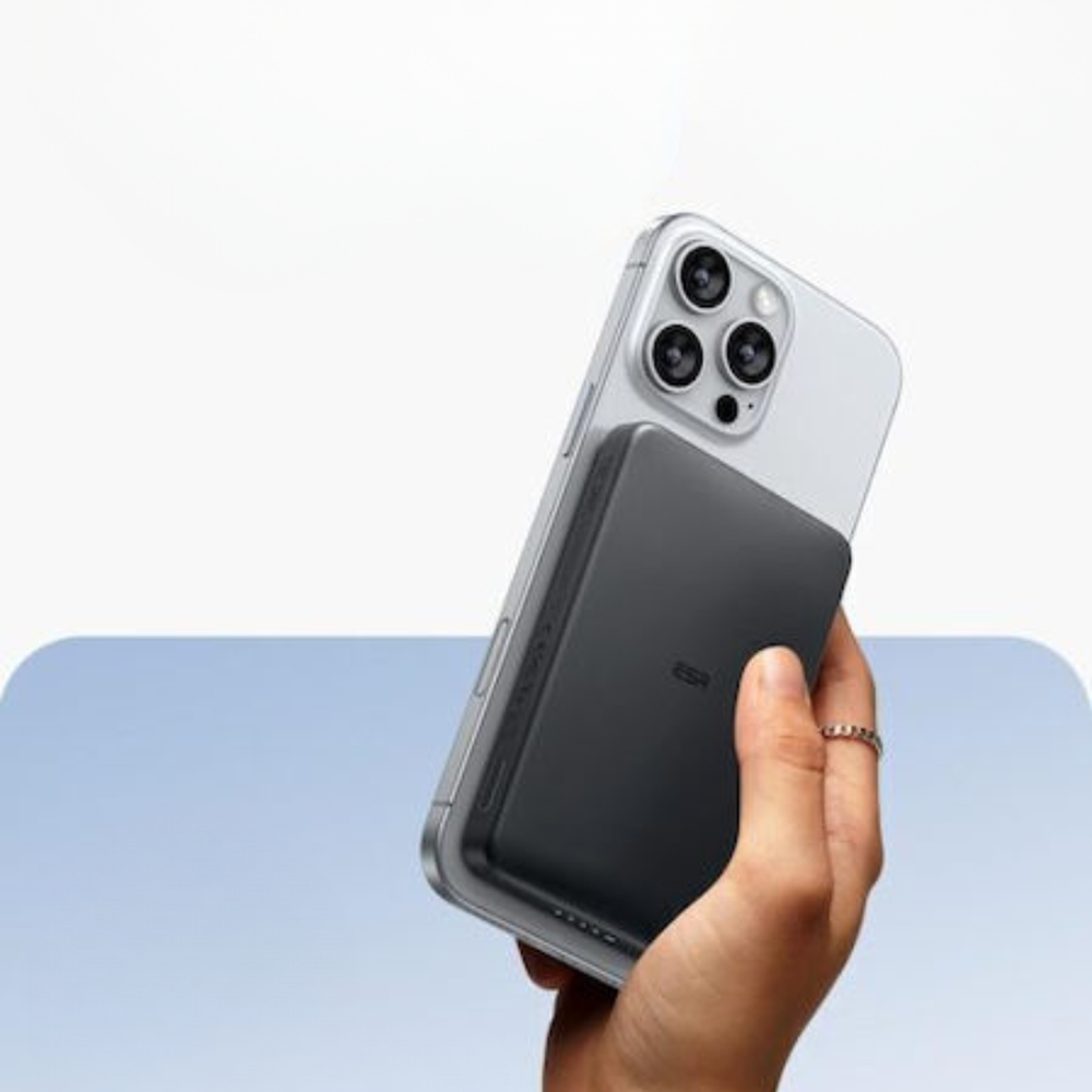 Hand holding silver iPhone with black ESR 10000mAh magnetic power bank for portable charging