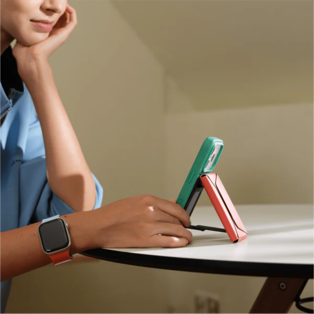 Teal and coral MagSafe wallet stand holding smartphone