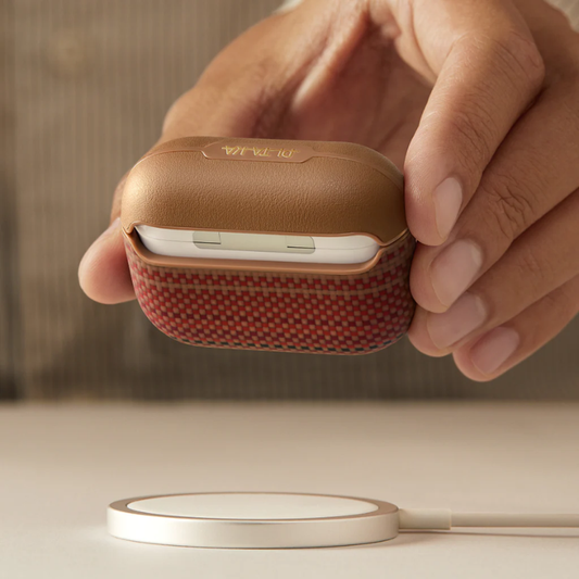 Tan Pitaka AirPods Pro 3 case on wireless charging pad with open lid