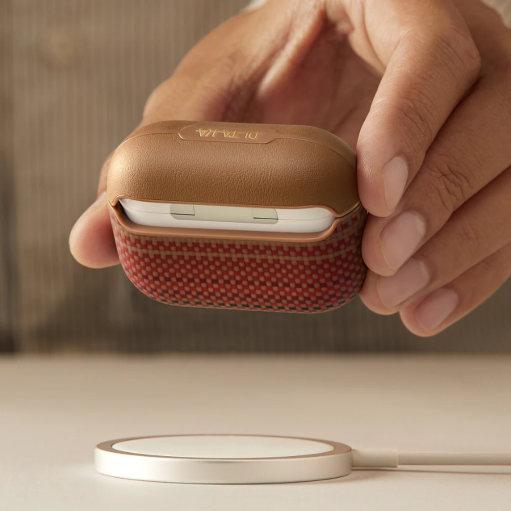 Tan Pitaka AirPods Pro 3 case on wireless charging pad with open lid