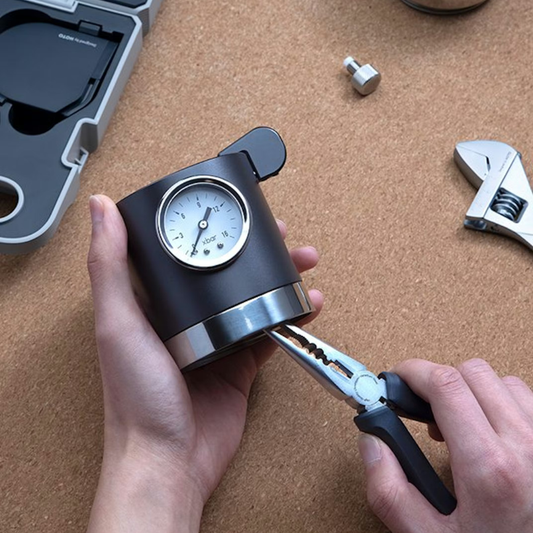 Close-up of HOTO pliers gripping tool base with pressure gauge