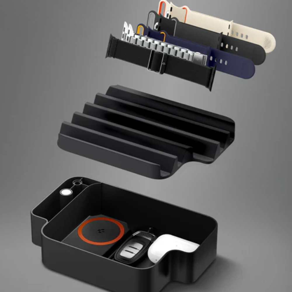 Disassembled black TPU Apple Watch organizer showing charging pad and band storage slots