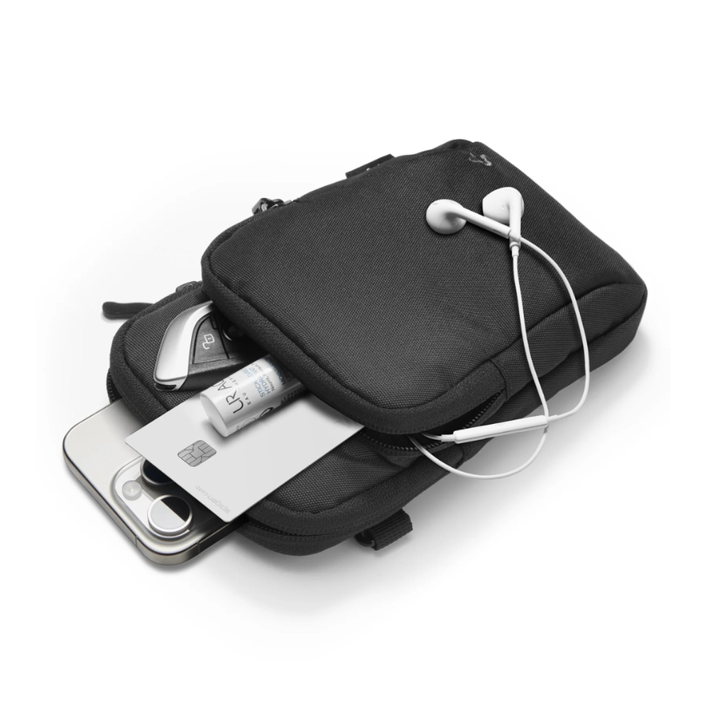 Open black Spigen crossbody bag holding smartphone and accessories