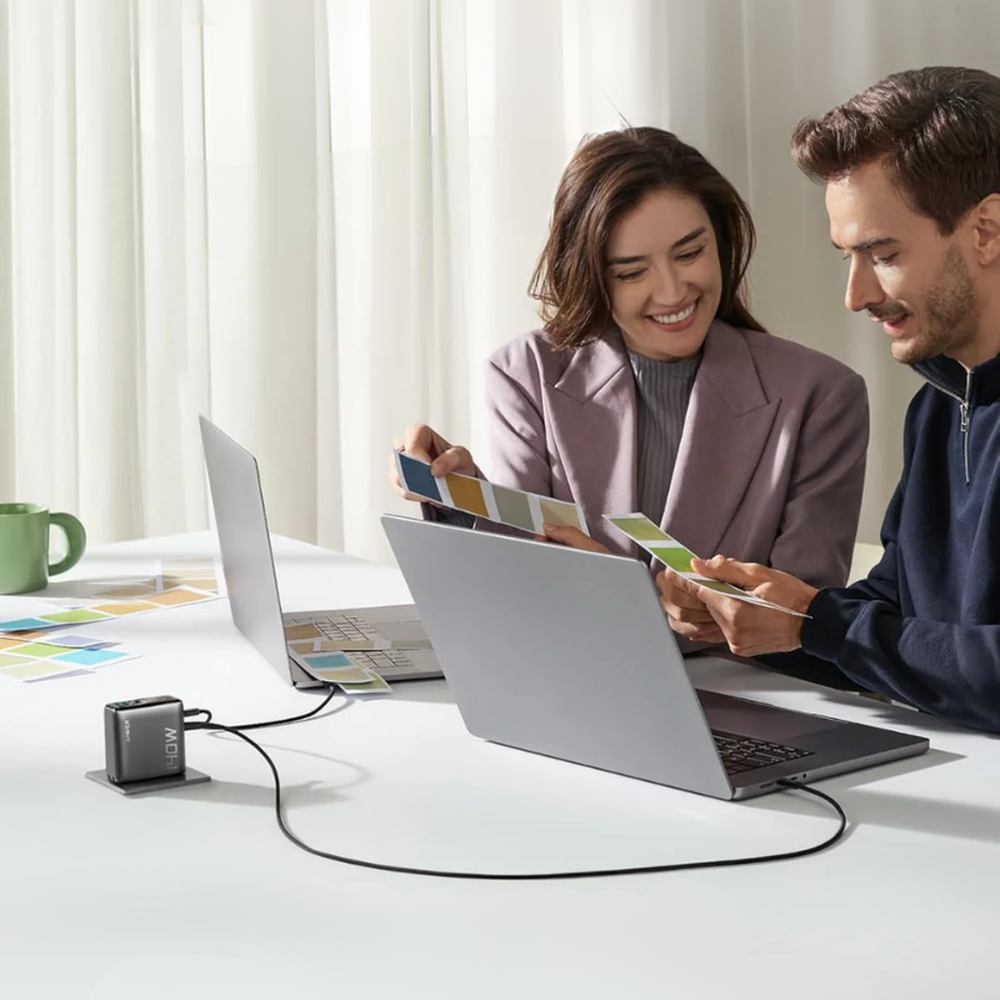 Anker 140W USB-C wall charger with smart display powering laptops in home office
