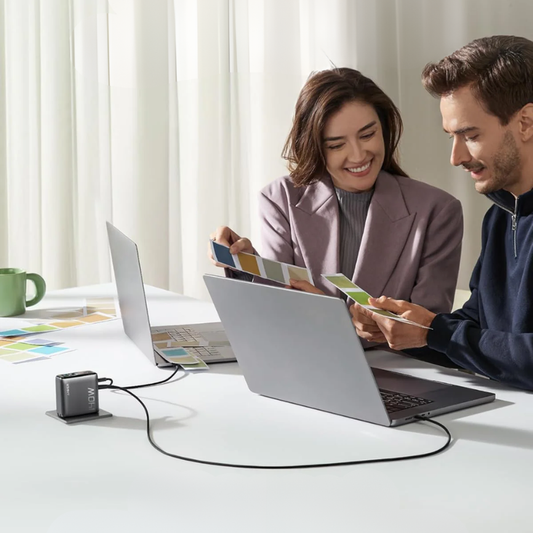 Anker 140W USB-C wall charger with smart display powering laptops in home office