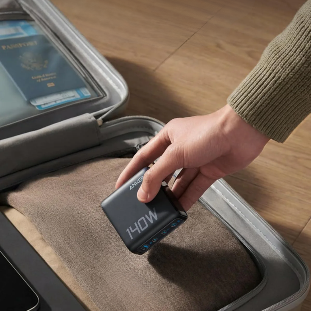 Compact Anker 140W travel charger with indicator lights inside gray carrying case