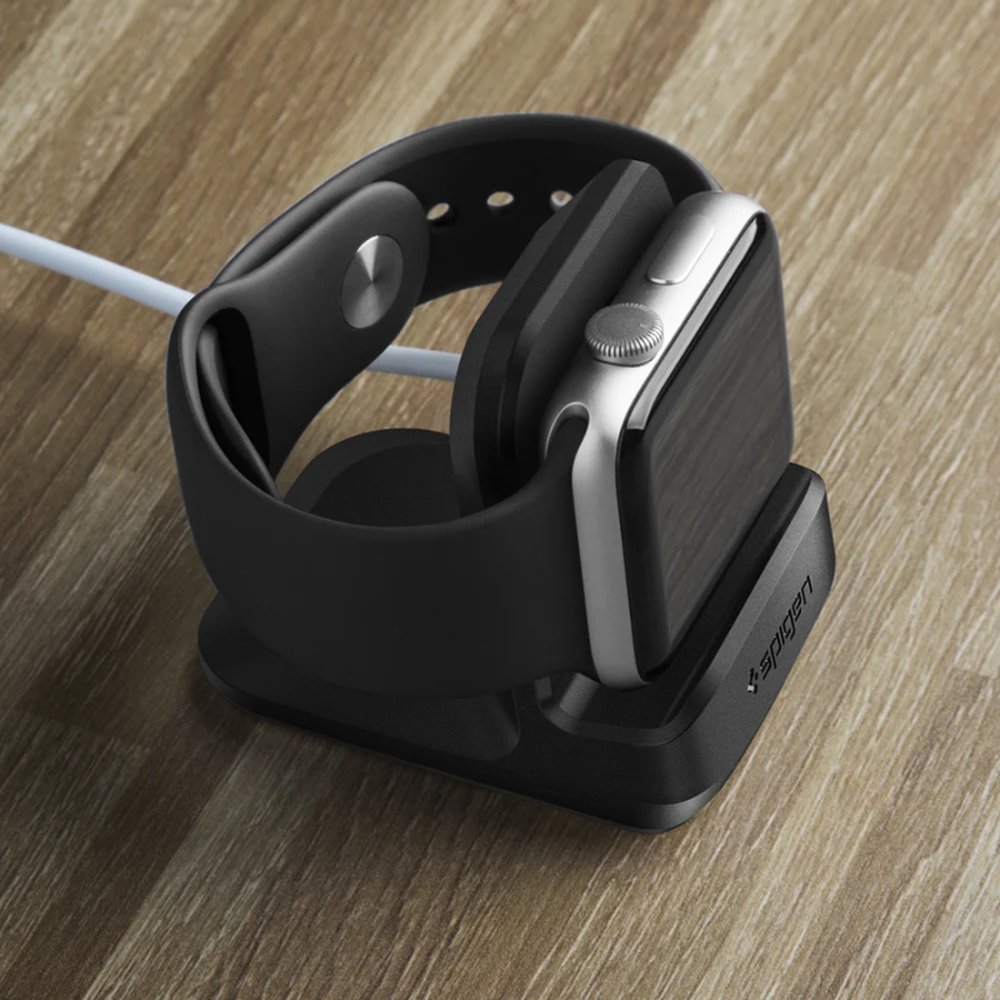 Black Spigen charging stand on wood surface showing angled fit and side cable connection for Apple Watch