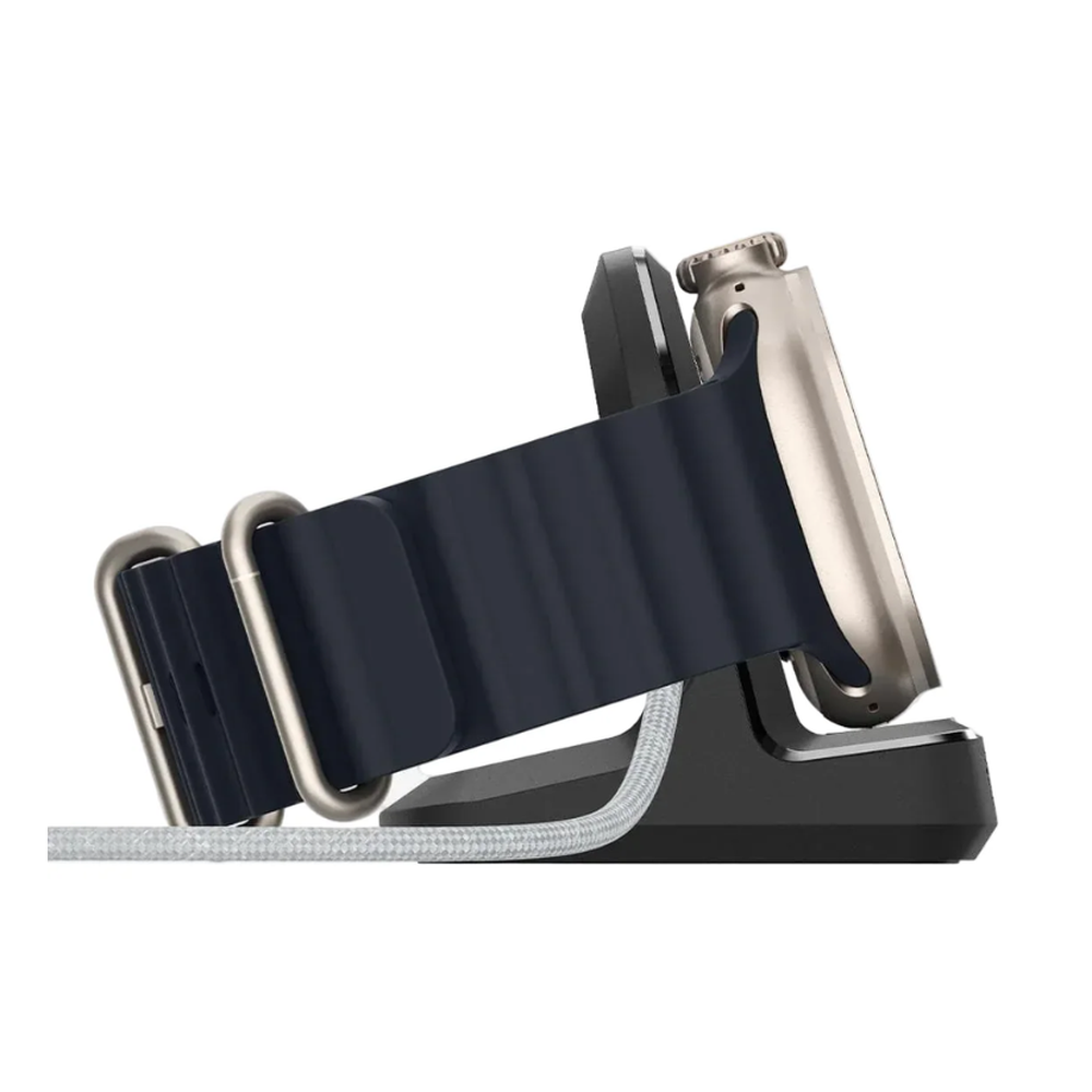 Black Spigen watch stand holding silver Apple Watch with blue silicone strap