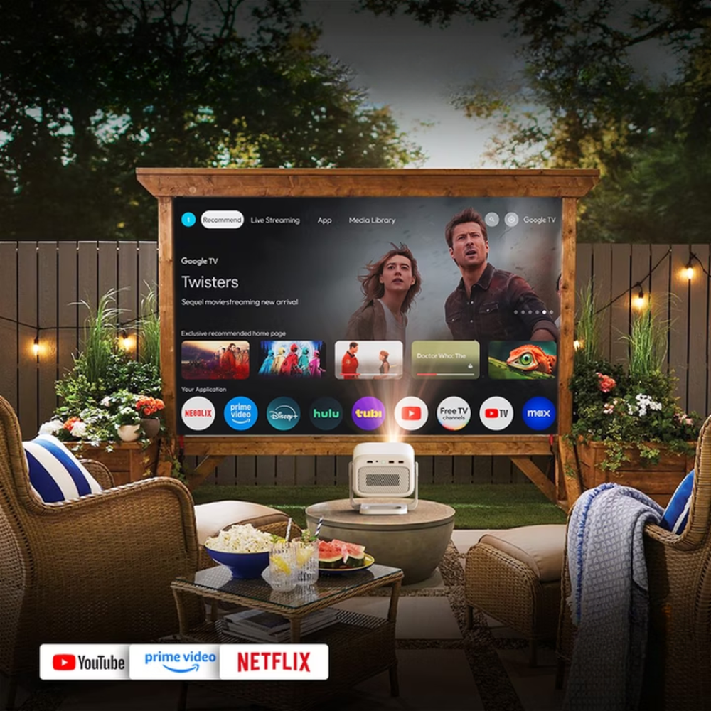 Byintek portable projector displaying Google TV streaming interface on outdoor patio