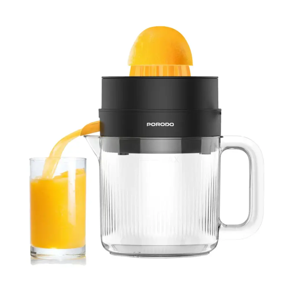 Pouring fresh orange juice from Porodo juicer into glass tumbler for easy serving