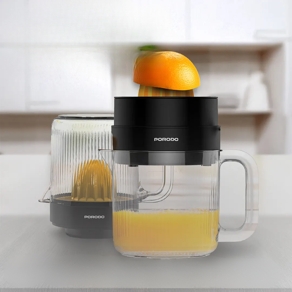 Porodo black and yellow electric juicer with ribbed glass pitcher making fresh orange juice