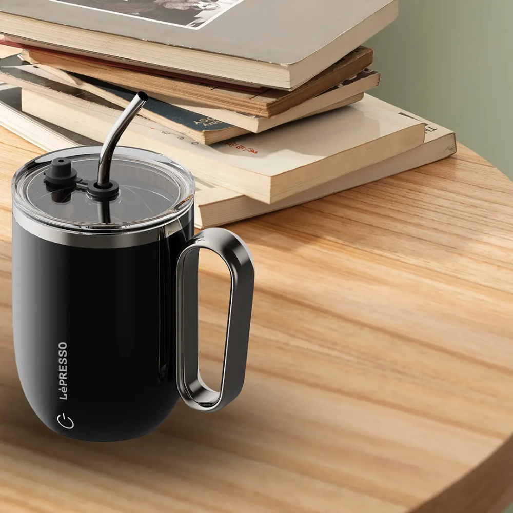 Lepresso black smart stirring mug on wood surface with books