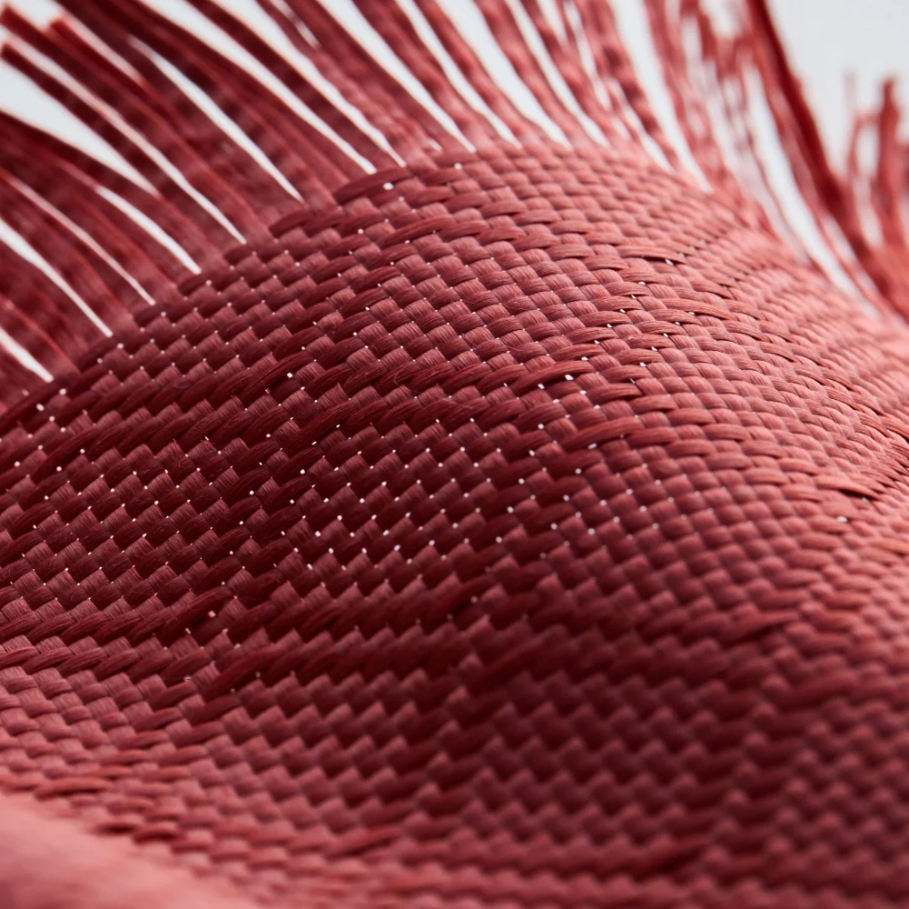 Deep red aramid fiber diagonal basketweave texture close-up