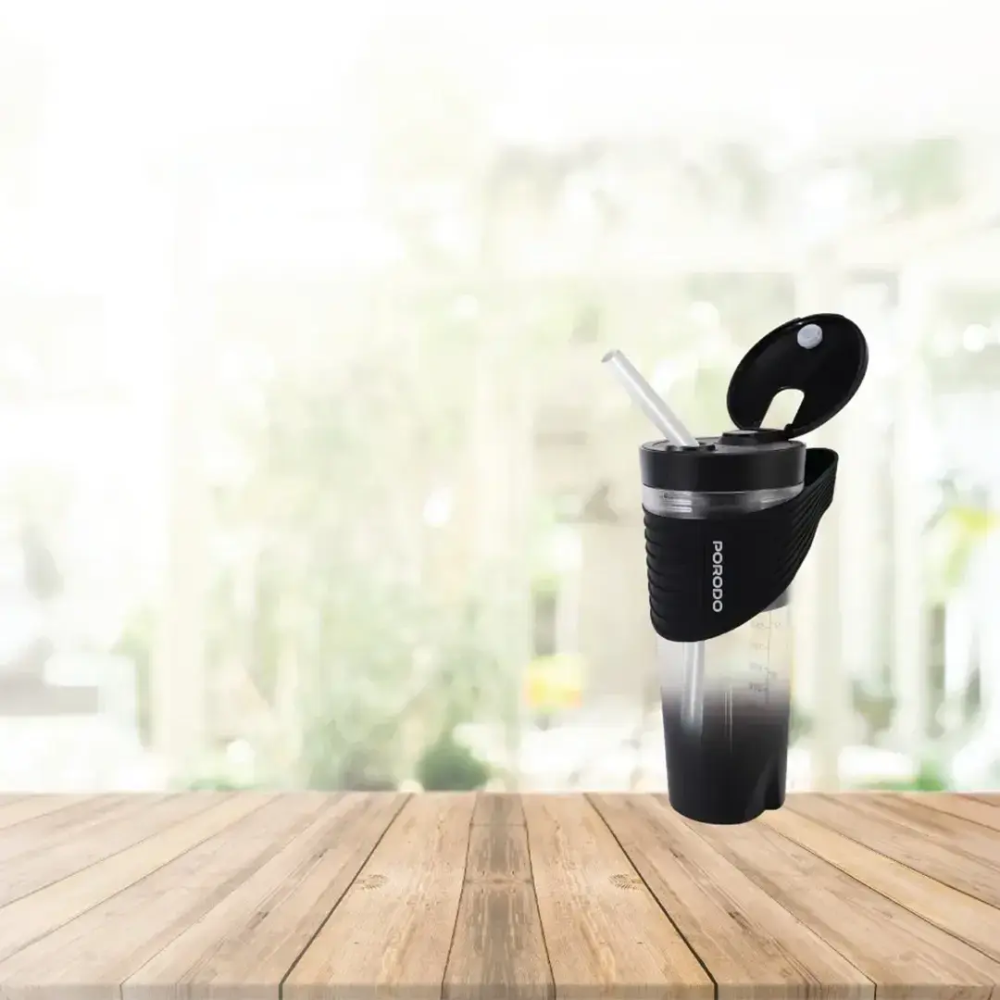 Black Porodo portable blender on wooden surface with hinged lid and straw