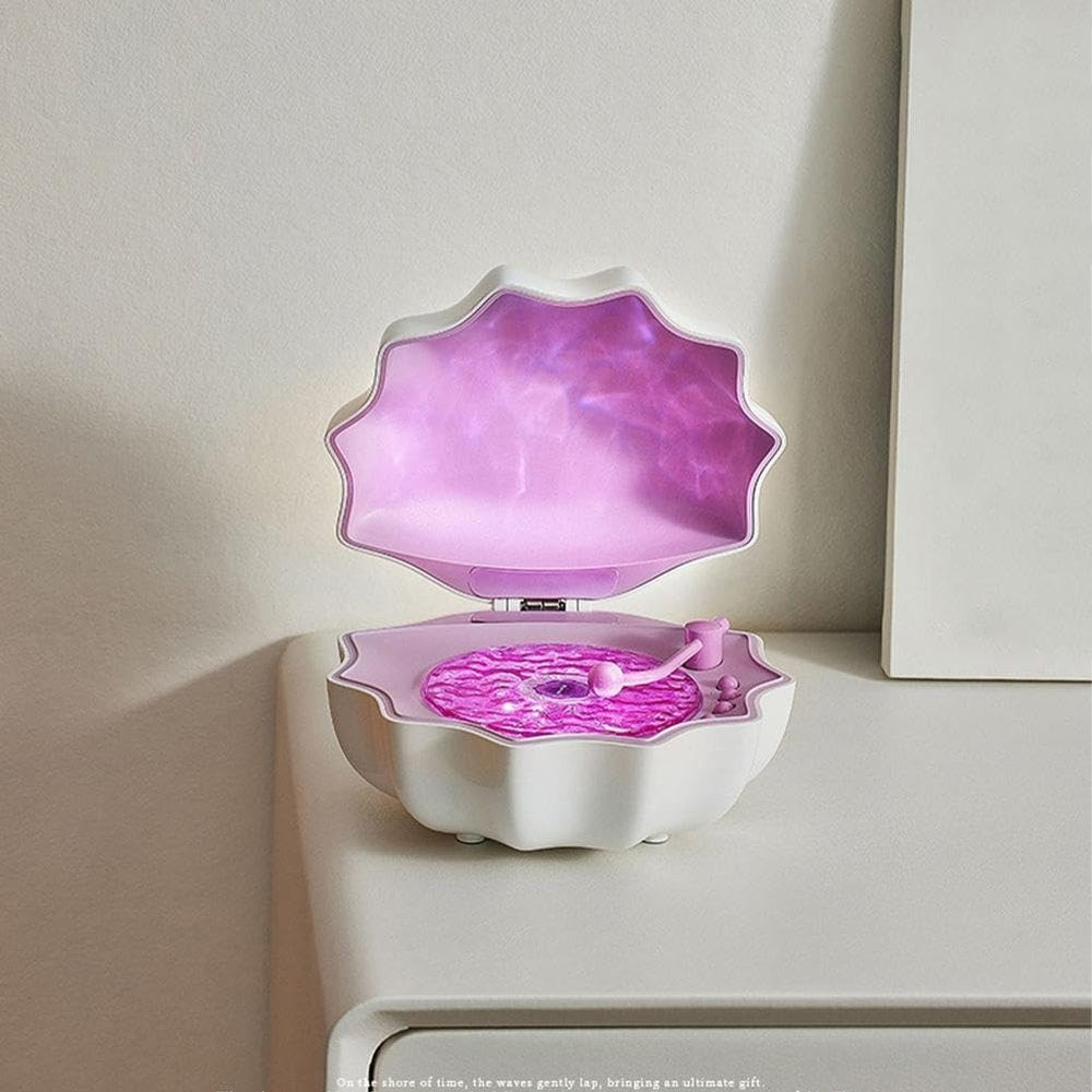 Pink shell-shaped Bluetooth speaker projector with glowing gradient night light and textured base