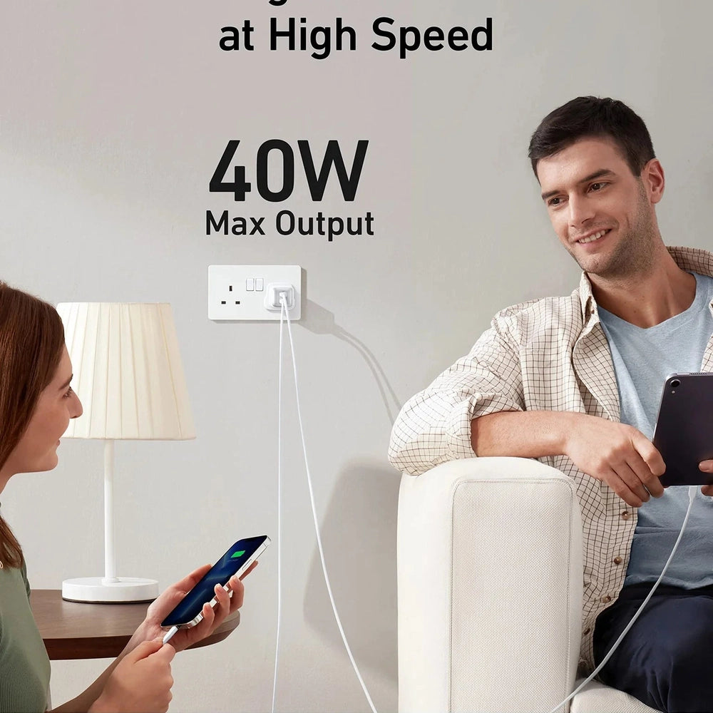 Anker 40W wall charger charging smartphone and tablet simultaneously in living room