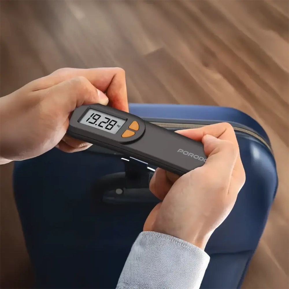 Porodo Accuscale black luggage scale weighing blue suitcase on wooden floor