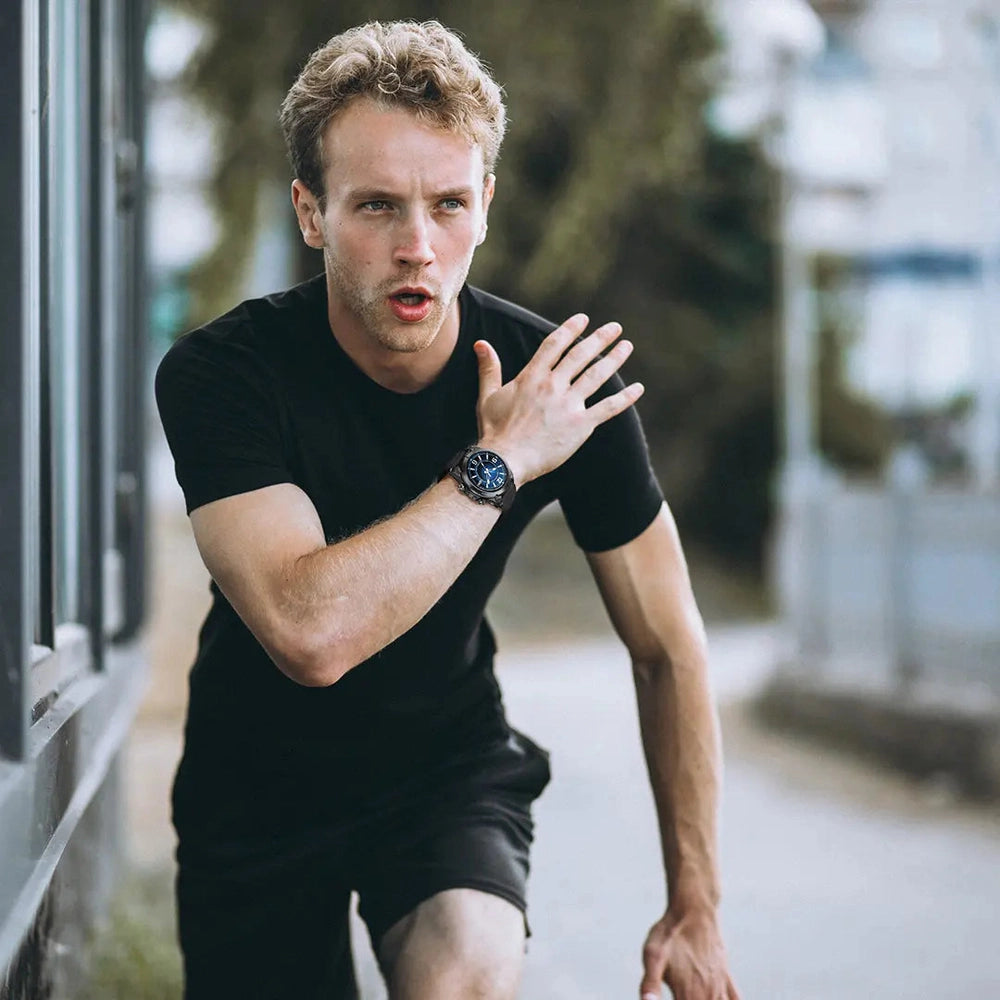 Man running outdoors wearing black Powerology Titan smartwatch with blue dial