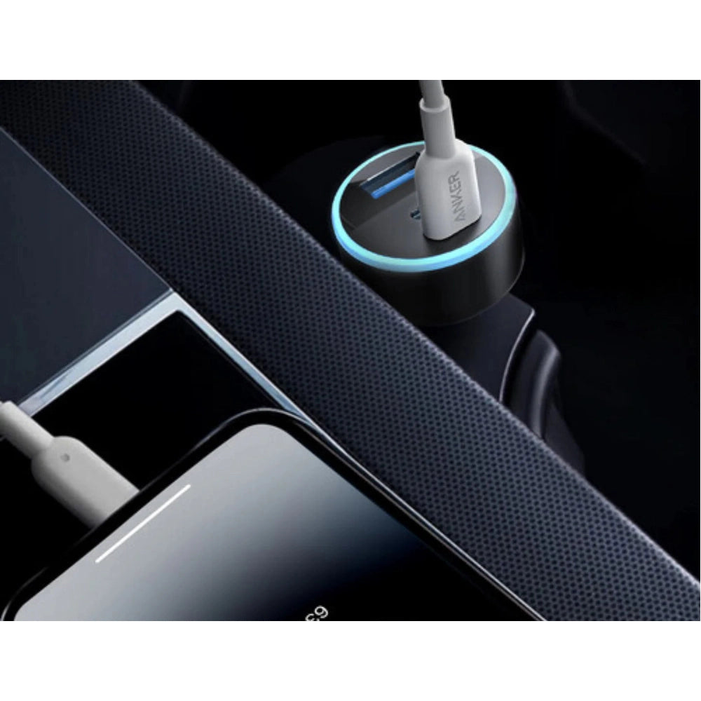 Close-up of Anker car charger with glowing blue ring and smartphone