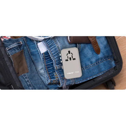 Gray Momax 70W travel adapter packed in suitcase with denim jeans for trip readiness